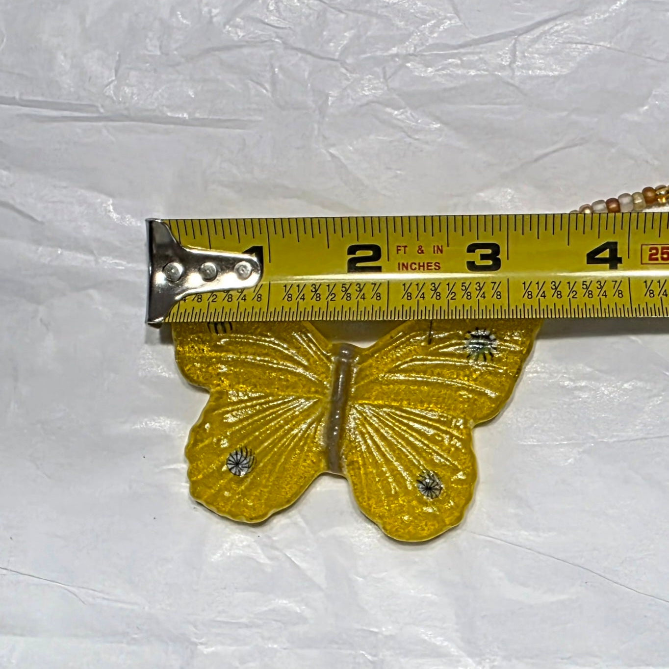 Yellow butterfly being measured for width; 3.25ish inches.