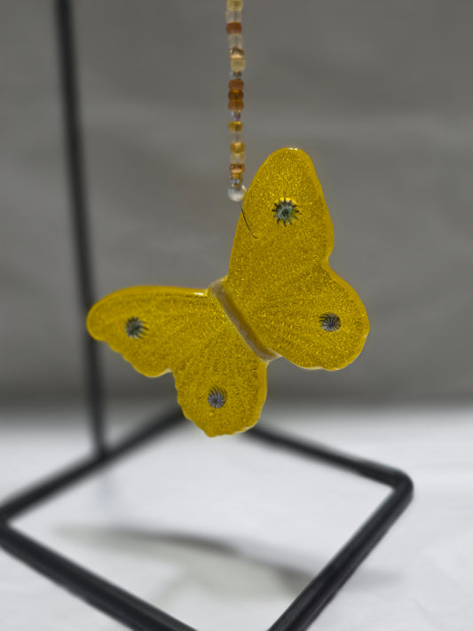 Yellow butterfly hanging from a beaded wire