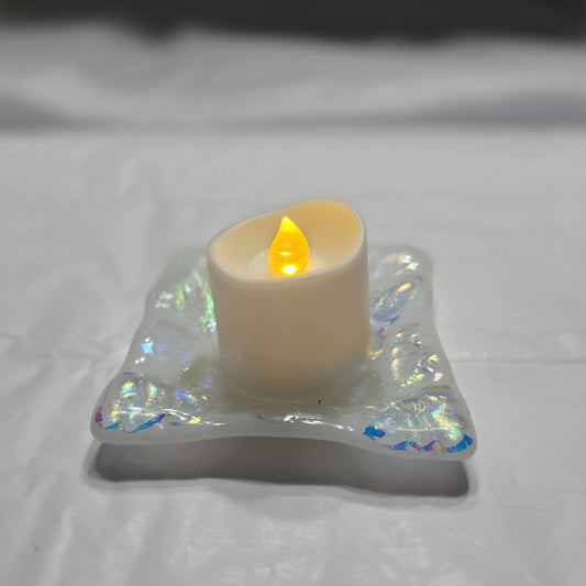 White dish with sparkle design that is displayed as a candle holder, displays a battery operated candle.