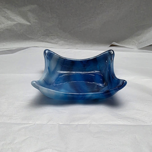 little dishes that are streaky white and blue. Dish is sitting on a white surface.