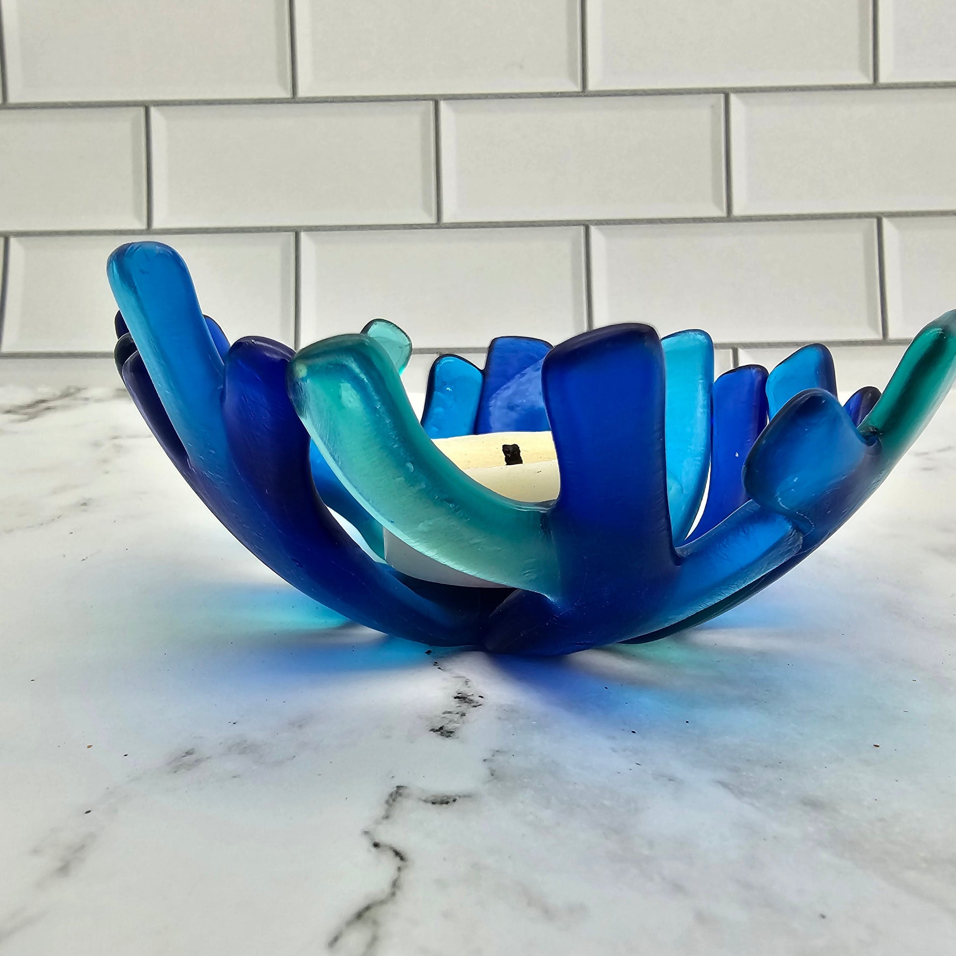 Coral style bowl in varied shades of blue on a white surface. 