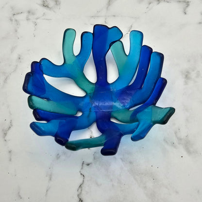 Coral style bowl in varied shades of blue on a white surface. 