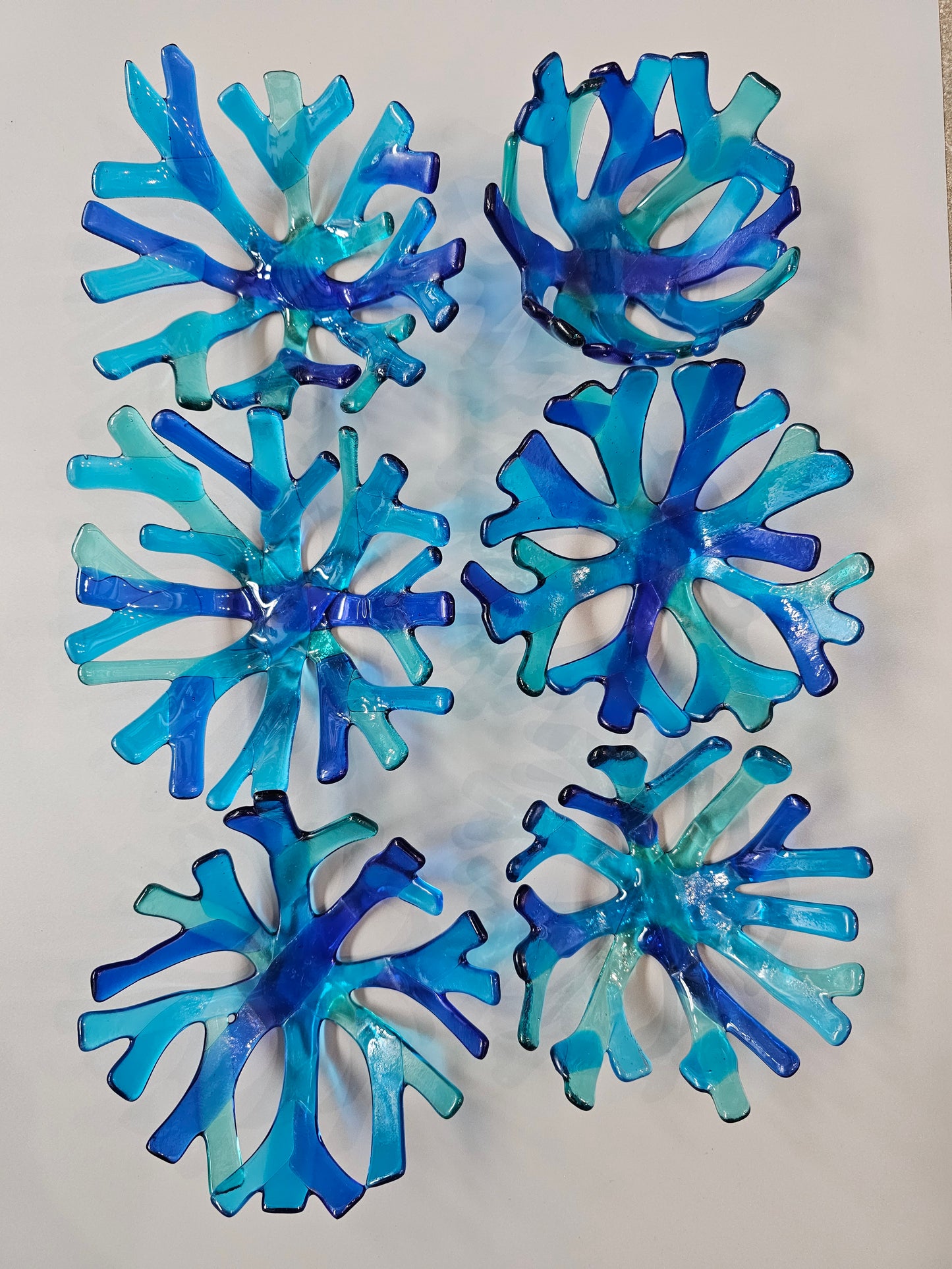 varied Coral style bowl in various shades of blue on a white surface. 