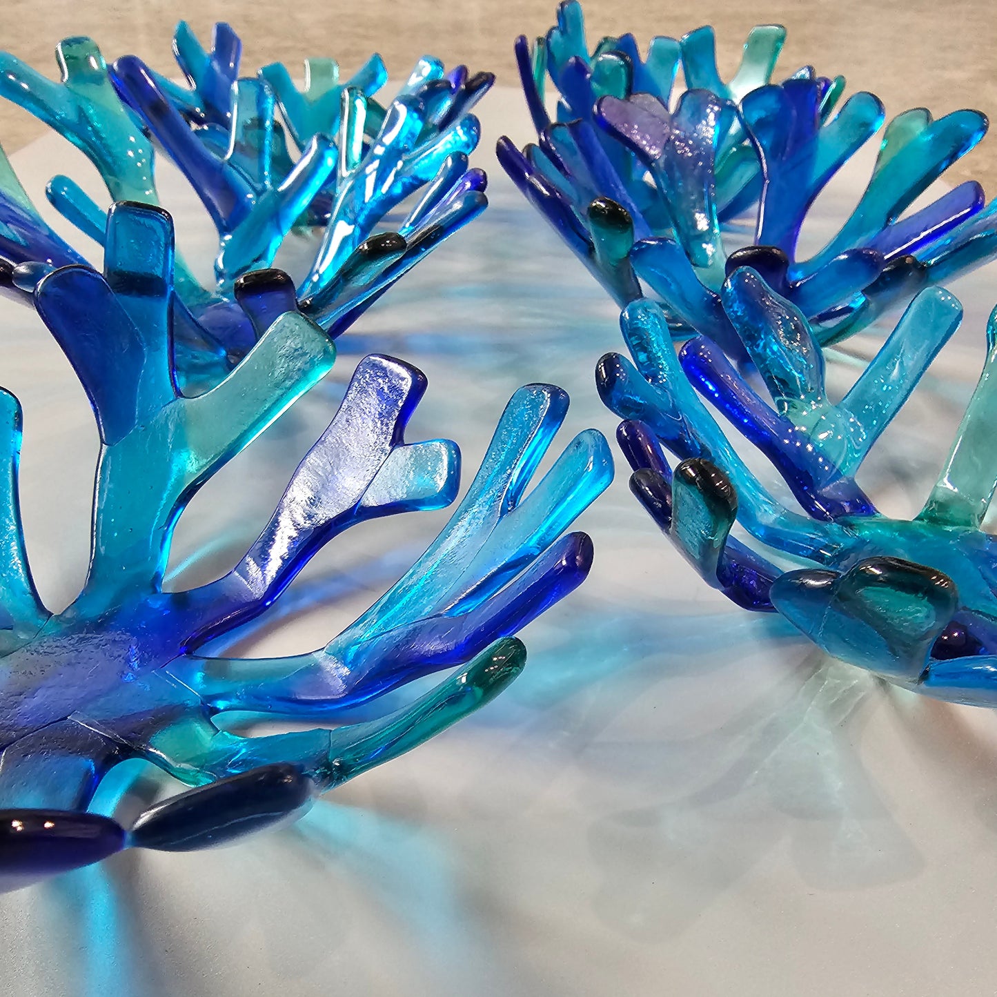 Varied Coral style bowl in varied shades of blue on a white surface. 