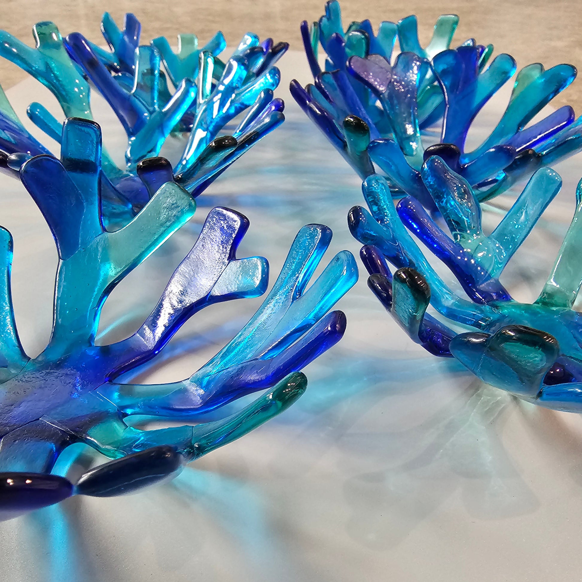 Varied Coral style bowl in varied shades of blue on a white surface. 