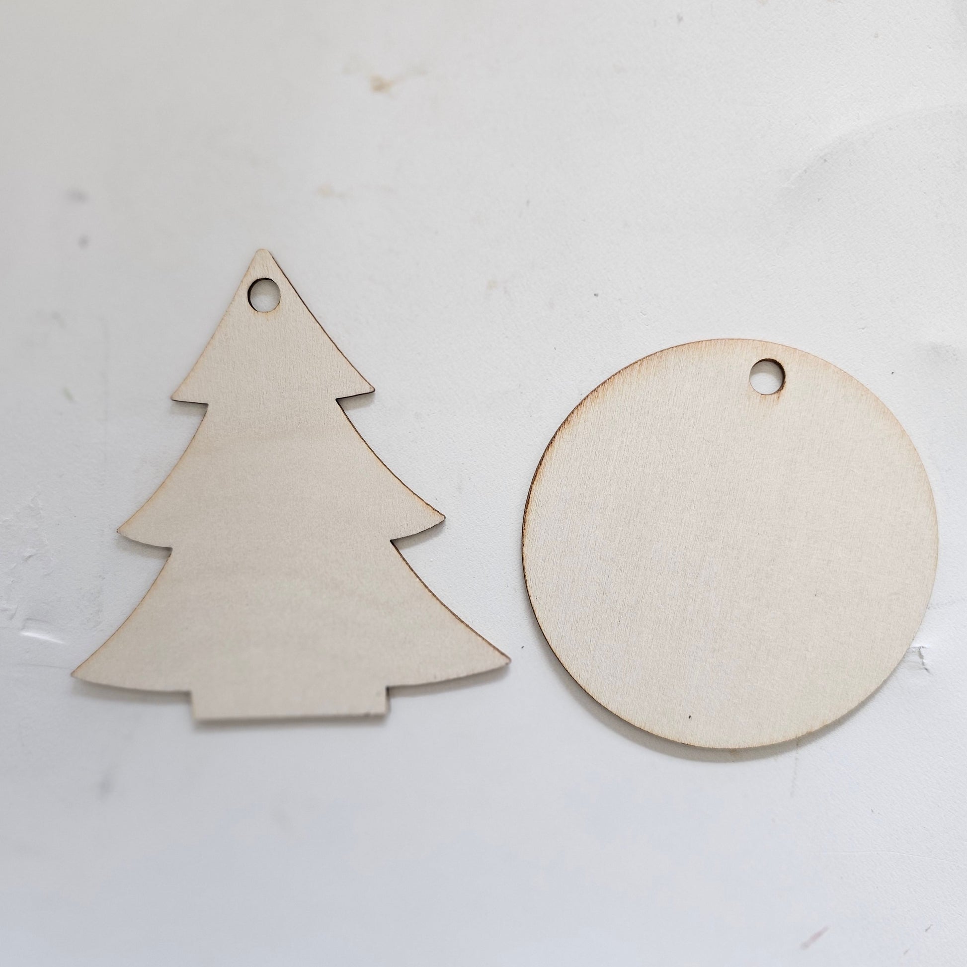 Two wooden cutout ornaments, one round and one tree-shaped.  Small 2.75" ornament bases.