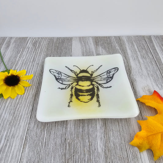 handcrafted dish features a screen-printed bumblebee that has been fused into the glass. The bee’s details add a touch of nature-inspired beauty to this functional piece. trinket dish, a jewelry holder, or simply displayed