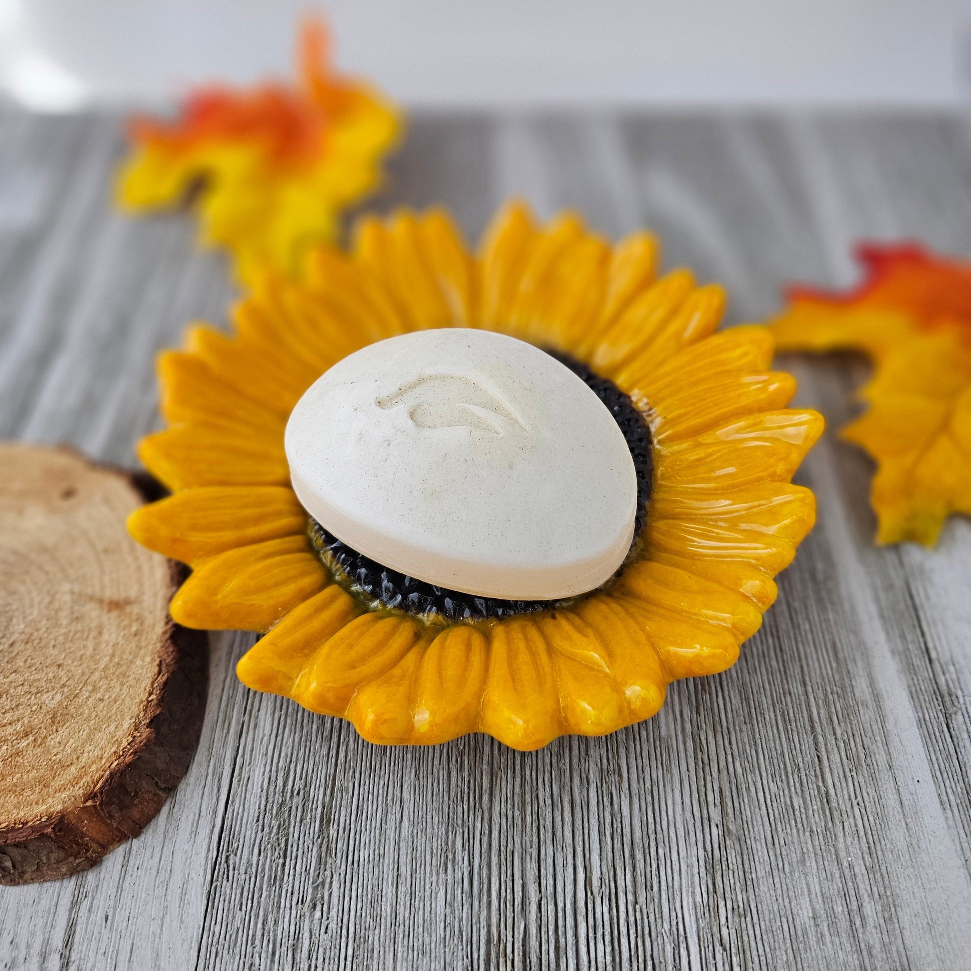 shades of yellow and orange sunflower with a dark brown center used as a soap dish