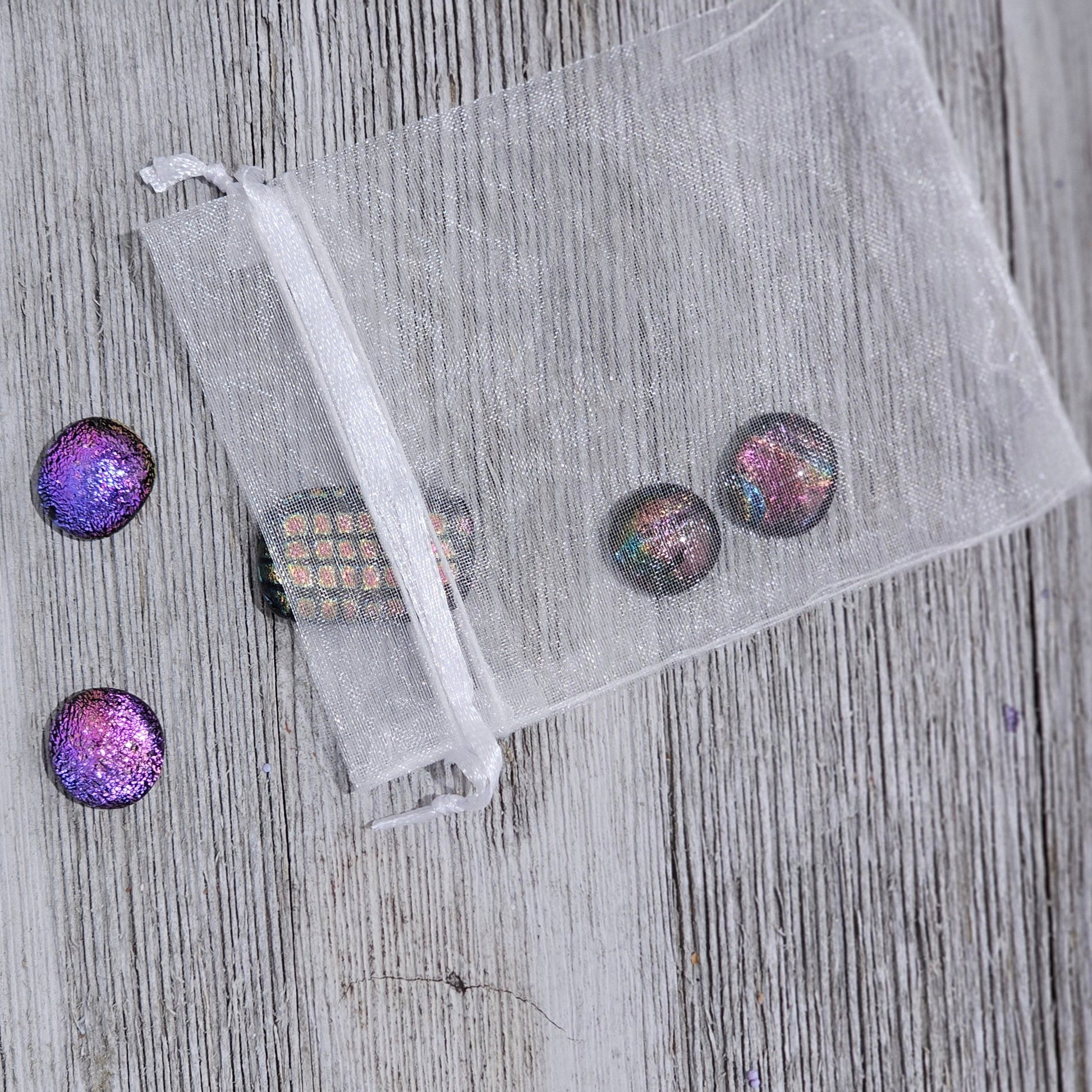 Lot of 5 dichroic glass pieces: Four pieces approx. 0.5"x0.5" and one 1"x0.5", all handmade and topped with clear glass for extra sparkle. The pieces have an organic shape due to their handmade nature. Dots come in an organza bag.