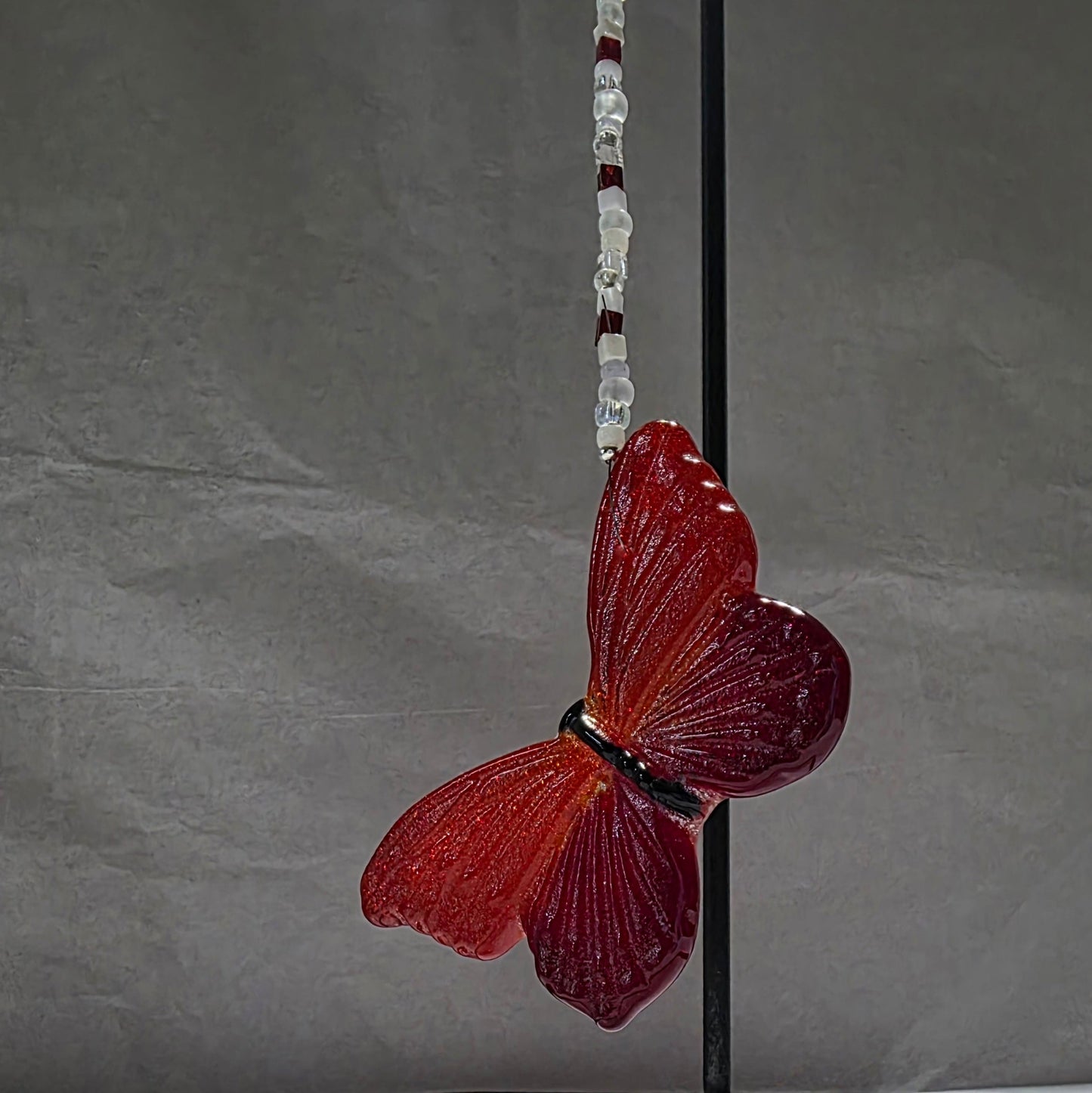 Butterfly-shaped object on a stand against a gray background