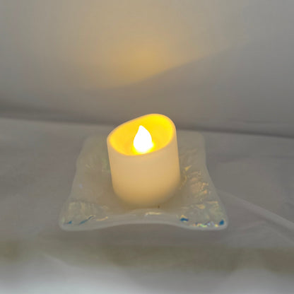 White dish with sparkle design that is displayed as a candle holder, displays a battery operated candle. 