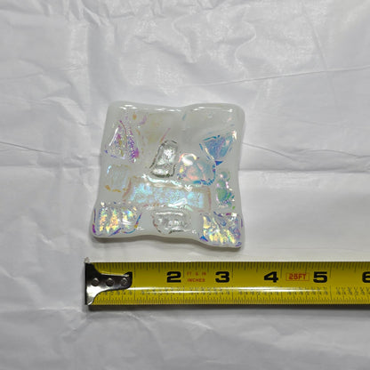 Iridescent square dish with a measuring tape on a white background