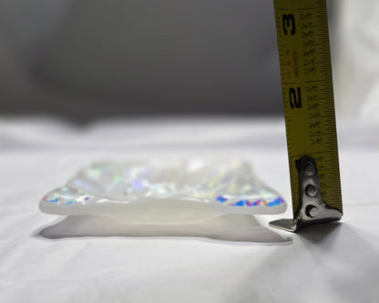 Measuring tape on a crystal pendant against a white background