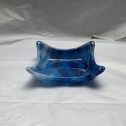 little dishes that are streaky white and blue. Dish is sitting on a white surface.