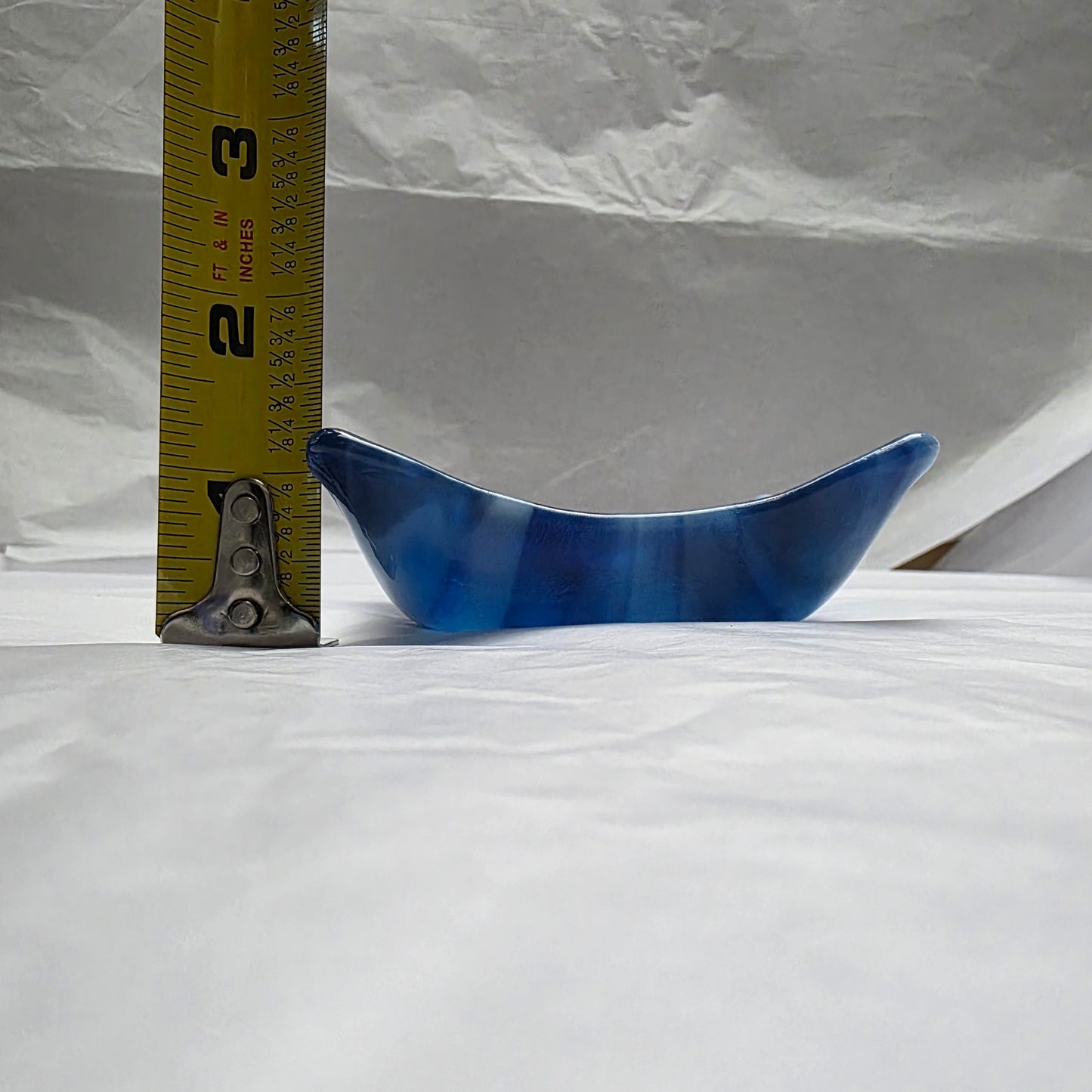 Various blue and white streaky colored little dish next to a tape measure.  Depth approximately 1.5 inches.