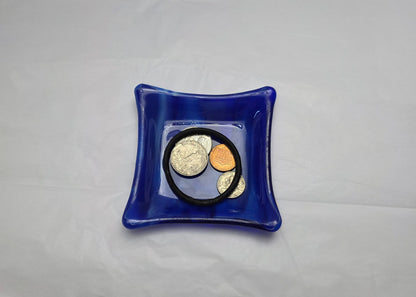 Various blue and white streaky colored little dish.  Dish is on a white surface. The little dish has coins and a hair tie indicating can be used as a trinket or ring dish.