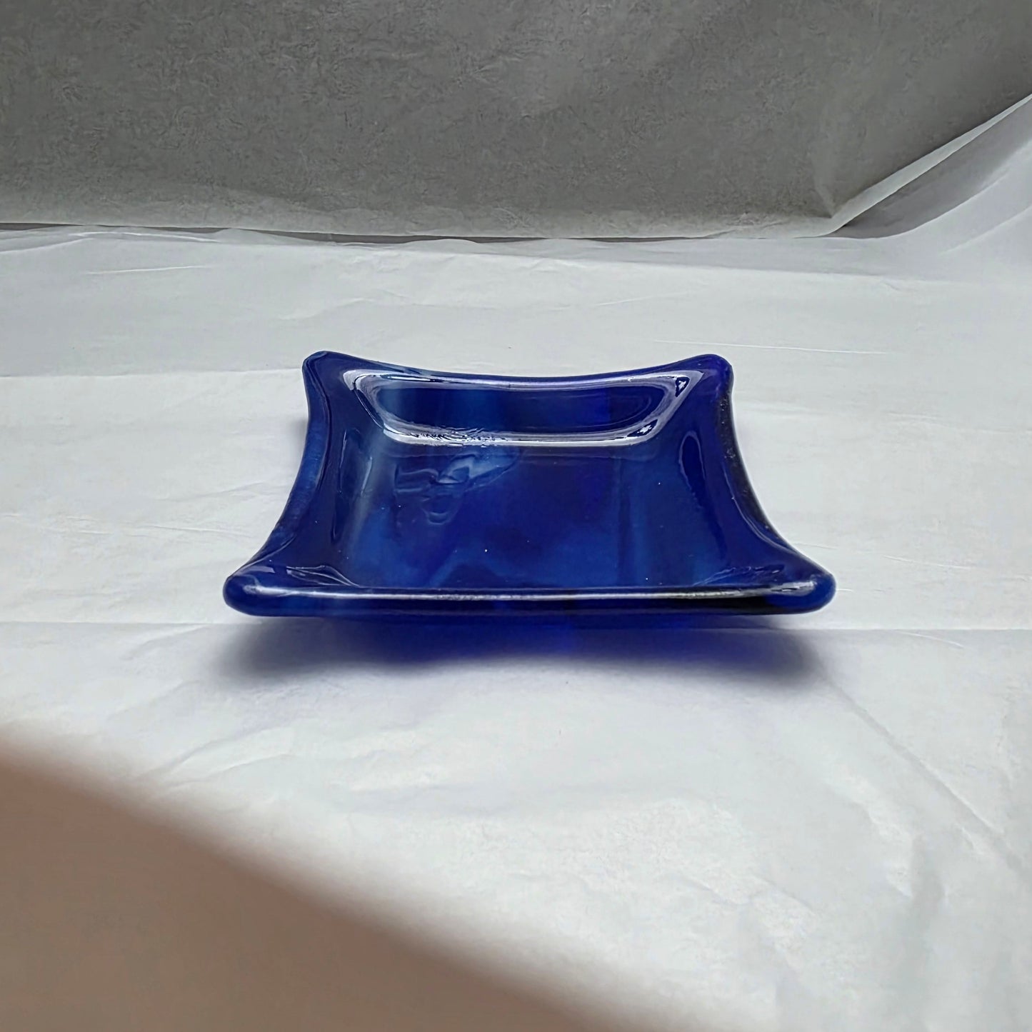 a little blue and white streaky dish on a white surface.