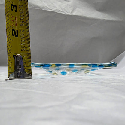 Glass dish with blue and yellow polka dots being measured against a white background