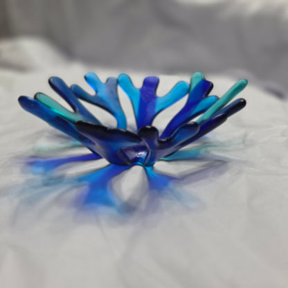 Coral style bowl in varied shades of blue on a white surface. 